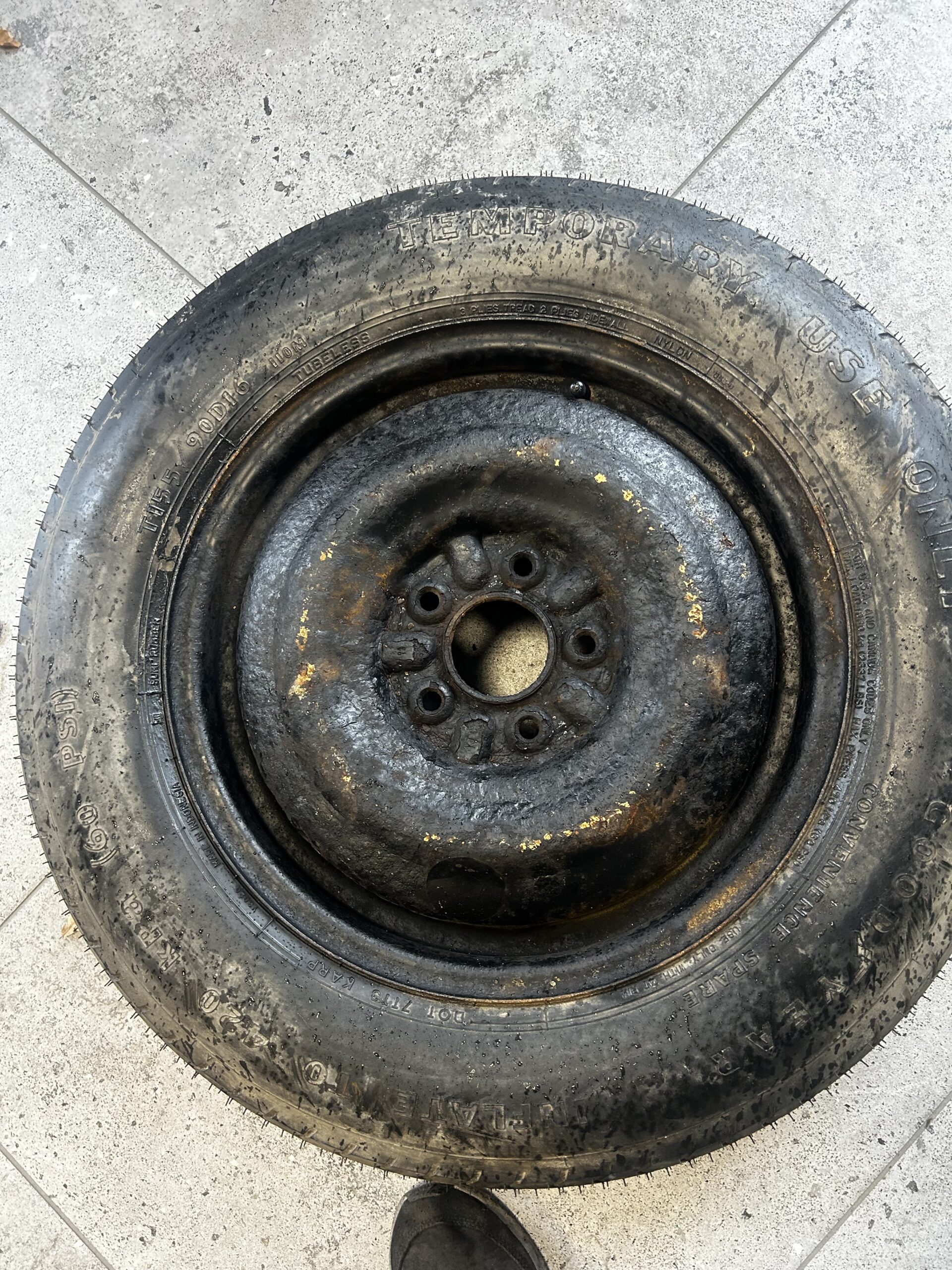 Koło dojazdowe przed renowacją, zardzewiała felga stalowa i opona przed procesem piaskowania i lakierowania proszkowego